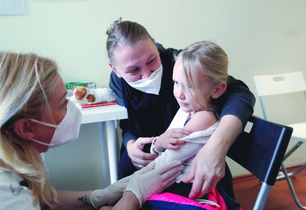 Julia, 6-years-old is comforted by her mother after she gets a dose of the Pfizer-BioNTech COVID-19 vaccine, in the Bethesda Children's Hospital during a vaccination program for children aged 5-11 years, in Budapest, Hungary, on Wednesday. — Reuters