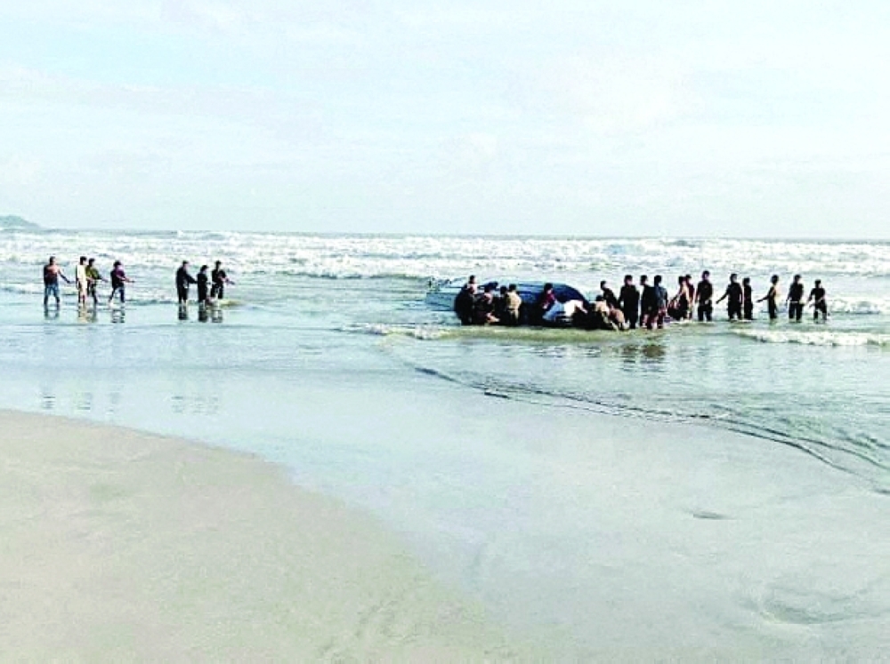 People search Tanjung Balau beach after a boat carrying migrants capsized. -- Reuters