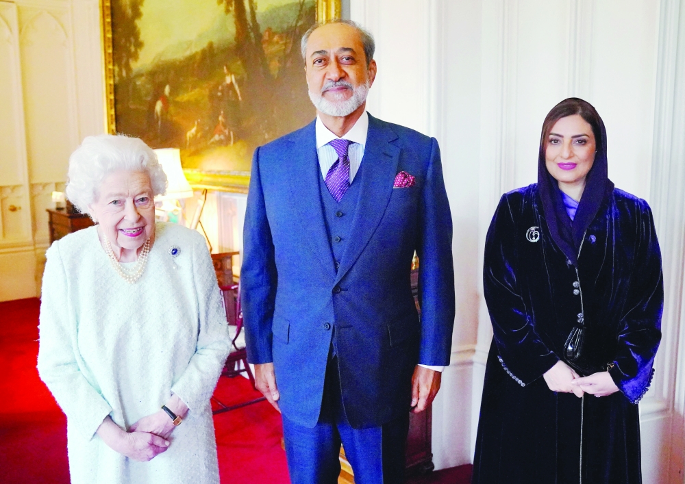 Britain's Queen Elizabeth II poses for a photograph with  the Sultan of Oman, Sultan Haitham bin Tariq and his wife, Sayyida Ahad Bint Abdullah Bin Hamad Al Busaidiyah, during an audience at Windsor Castle in Windsor, west of London on December 15, 2021. (Photo by Jonathan Brady / POOL / AFP)