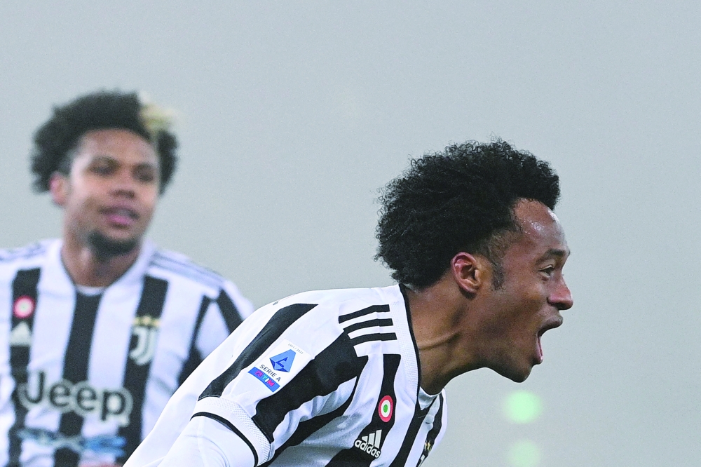 Juventus' Juan Cuadrado celebrates after scoring during the Serie A match against Bologna in Bologna. -- AFP