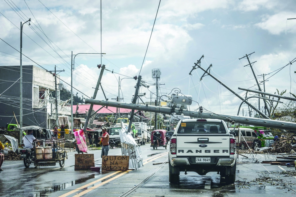 Fallen electric pylons block a road road in Surigao City days after super typhoon Rai devastated the city.  -- AFP