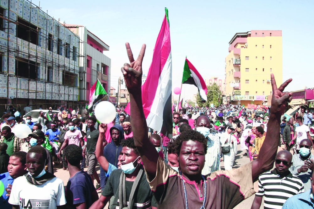 Sudanese youths raise national flags as they rally against the military chief who launched an October 25 coup followed by a bloody crackdown, in the northern part of Khartoum, on Sunday. - AFP
