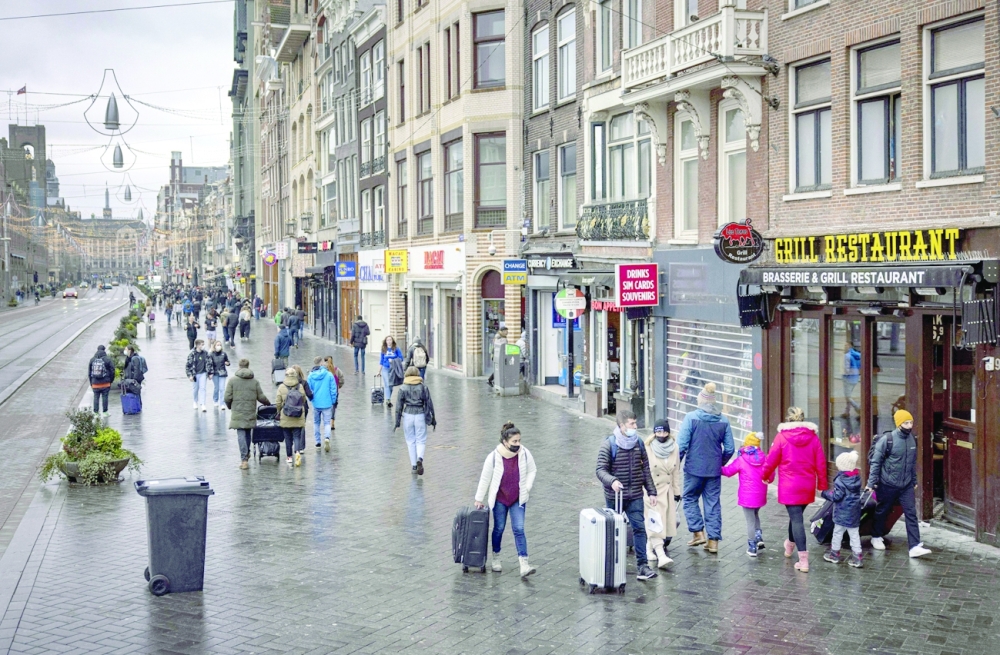 People walk on a quiet street in the center of Amsterdam as Netherlands go back into lockdown to fight the Covid-19 pandemic.  -- AFP