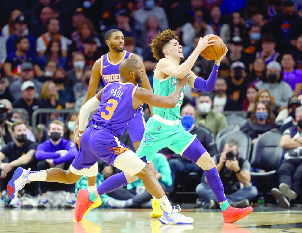 Charlotte Hornets guard LaMelo Ball (2) drives to the basket against Phoenix Suns' Chris Paul (3) in the first half at Footprint Center. -- USA Today Sports
