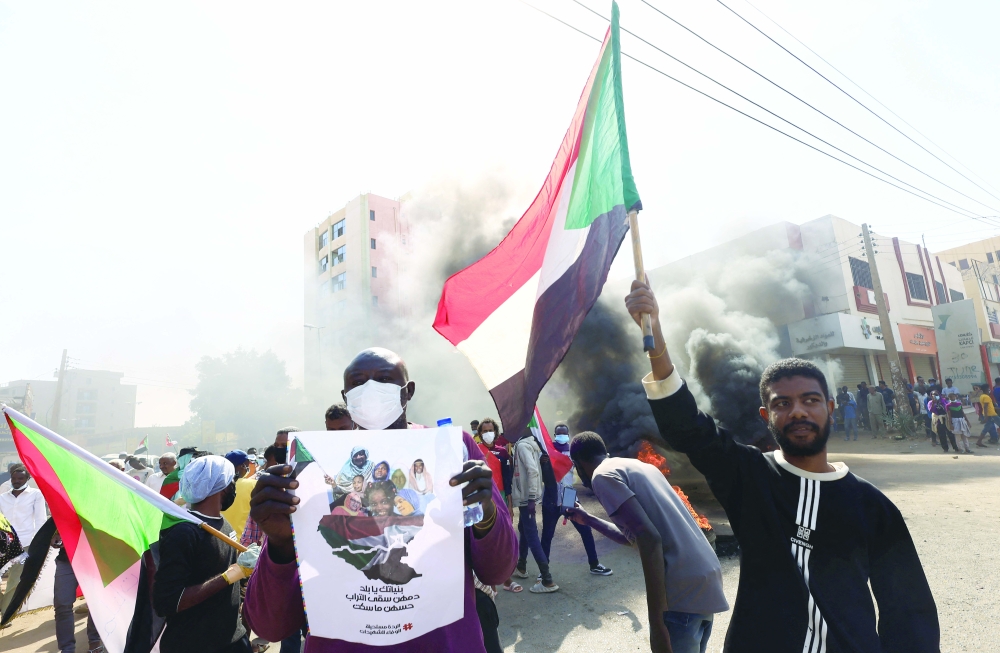 People march to the presidential palace, protesting against military rule following last month's coup in Khartoum, on Sunday. - Reuters