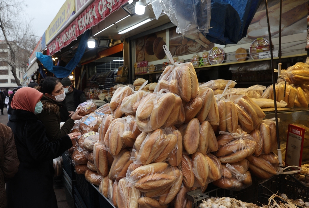 Women shop bread at a market in Ankara as Turkey's troubled lira nosedived 