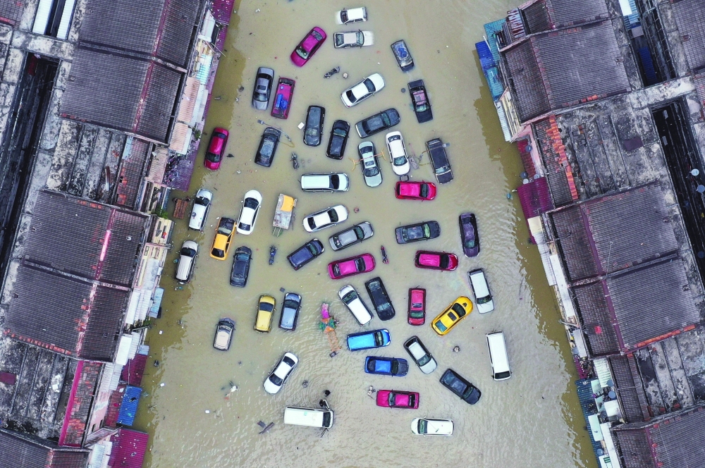 Aerial view shows vehicles and buildings inundated by floods in Shah Alam's Taman Sri Muda, one of the worst hit neighbourhoods in Selangor state, Malaysia, on Tuesday. - Reuters  