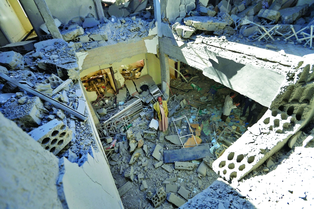 An airport worker walks through the debris of a building destroyed following a reported air strike by the coalition targeting the Ansar Allah-held  Sanaa International Airport on Tuesday. - AFP

