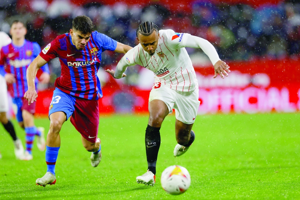Soccer Football - LaLiga - Sevilla v FC Barcelona - Ramon Sanchez Pizjuan, Seville, Spain - December 21, 2021 Sevilla's Jules Kounde in action with FC Barcelona's Abde Ezzalzouli REUTERS/Marcelo Del Pozo

