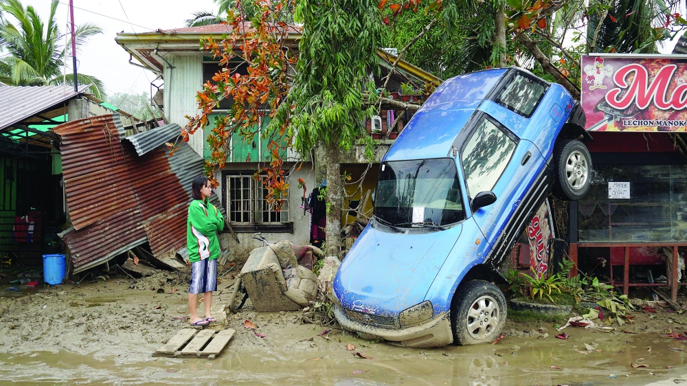 A resident looks at a vehicle swept away in Loboc town. -- AFP
