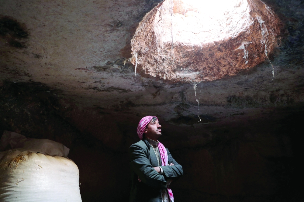 Mahmoud Abu Khalifa stands inside an ancient cave he uses to store his belongings and raise his sheep, at the UNESCO World Heritage Site of Babisqa, Syria. — Reuters 