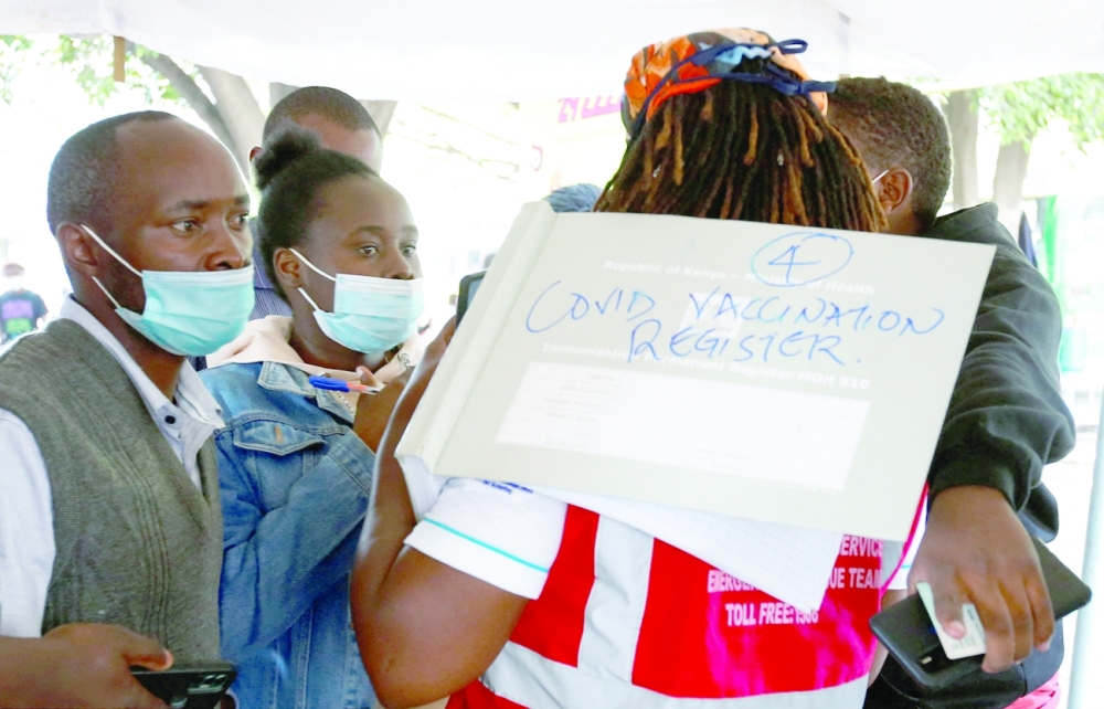 A health-worker talks to civilians before administering the Covid-19 vaccine at a makeshift tent in downtown Nairobi on Thursday. - Reuters
