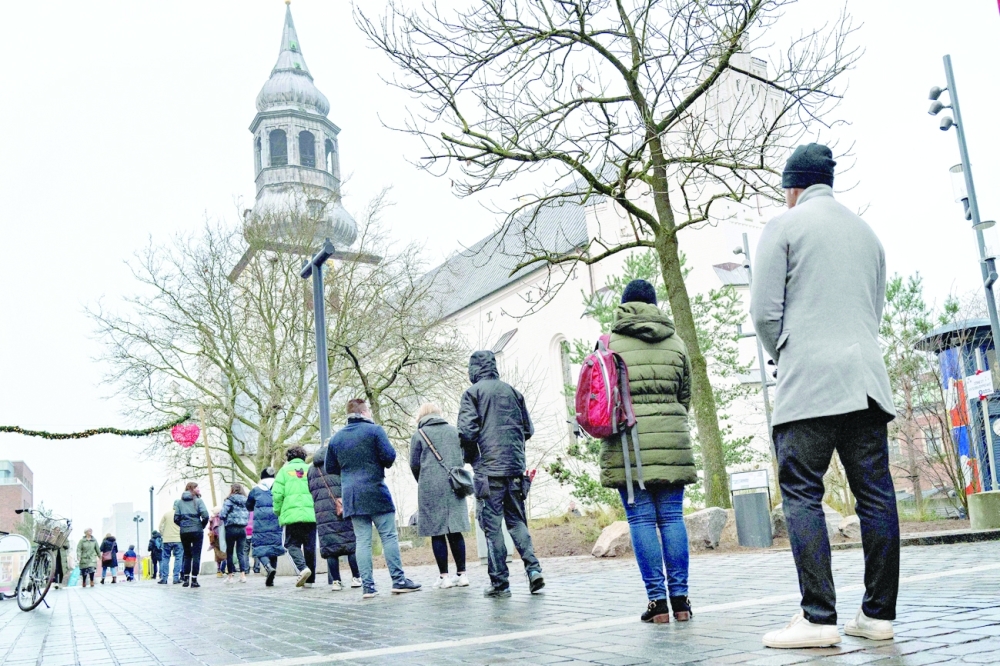 People queue for a rapid test at a test centre set up at Budolfi Church in the centre of Aalborg, Denmark on Thursday, during the Covid-19 pandemic. - AFP