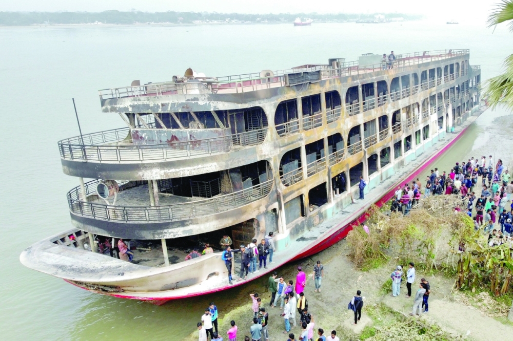 The burnt passenger ferry is seen anchored on the bank of Sugandha River in Jhalalathi, Bangladesh, on Friday. - Reuters