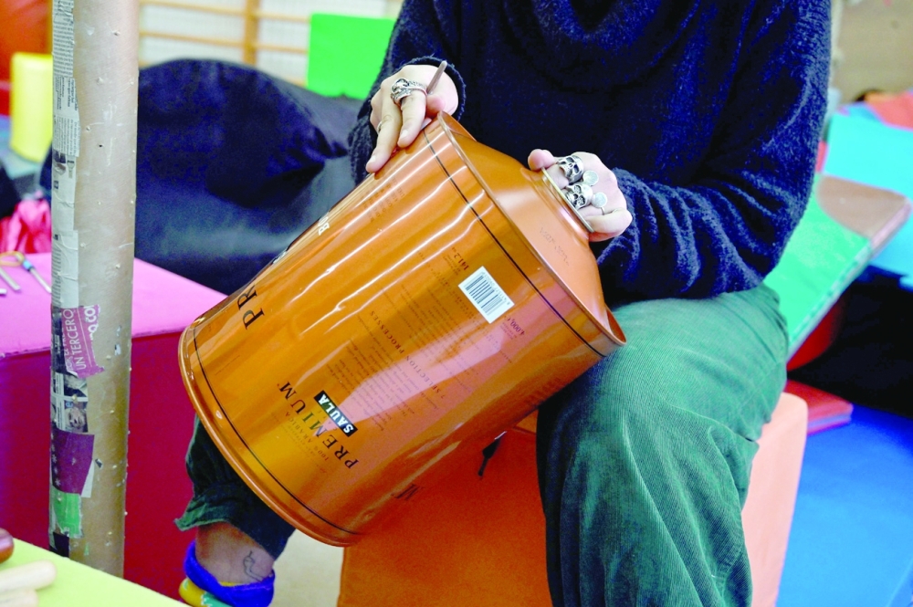 A member of the "Music of Recycling" orchestra, plays drums during a rehearsal in Madrid. — AFP