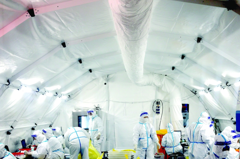 Medical workers work inside a makeshift nucleic acid testing laboratory set up in Xian. -- Reuters