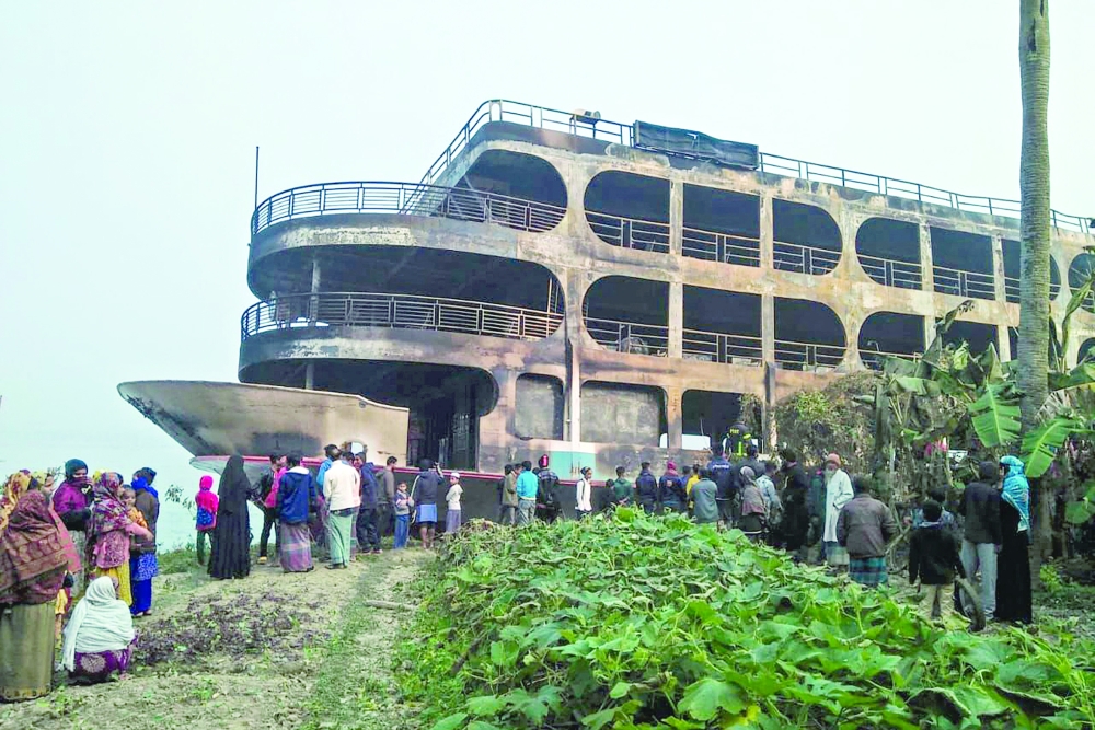 Villagers look at a burnt-out ferry in Jhakakathi. -- AFP
