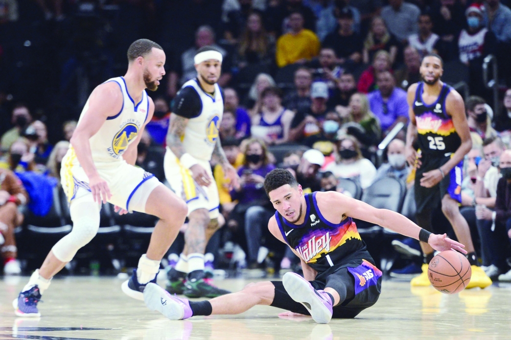 Phoenix Suns guard Devin Booker (1) is fouled by Golden State Warriors guard Stephen Curry (30) during the second half at Footprint Center. -- USA Today Sports
