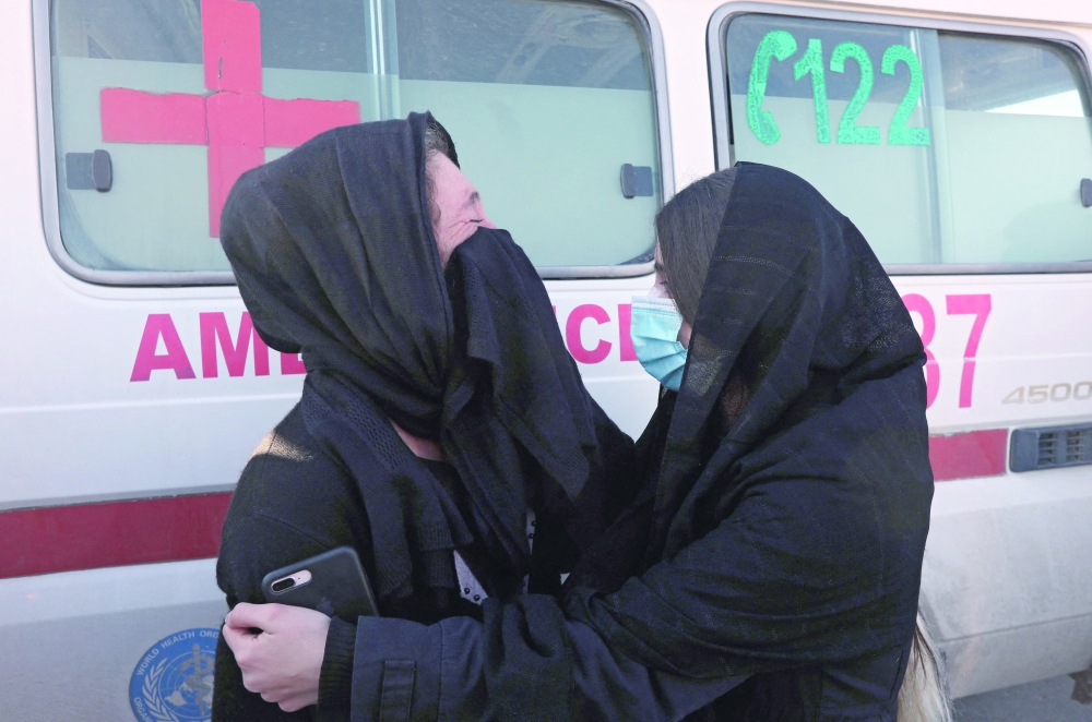 Relatives of the 16 Kurds, killed when their boat sank in the Channel while trying to reach England, attend their funeral in Arbil on Sunday. - AFP 