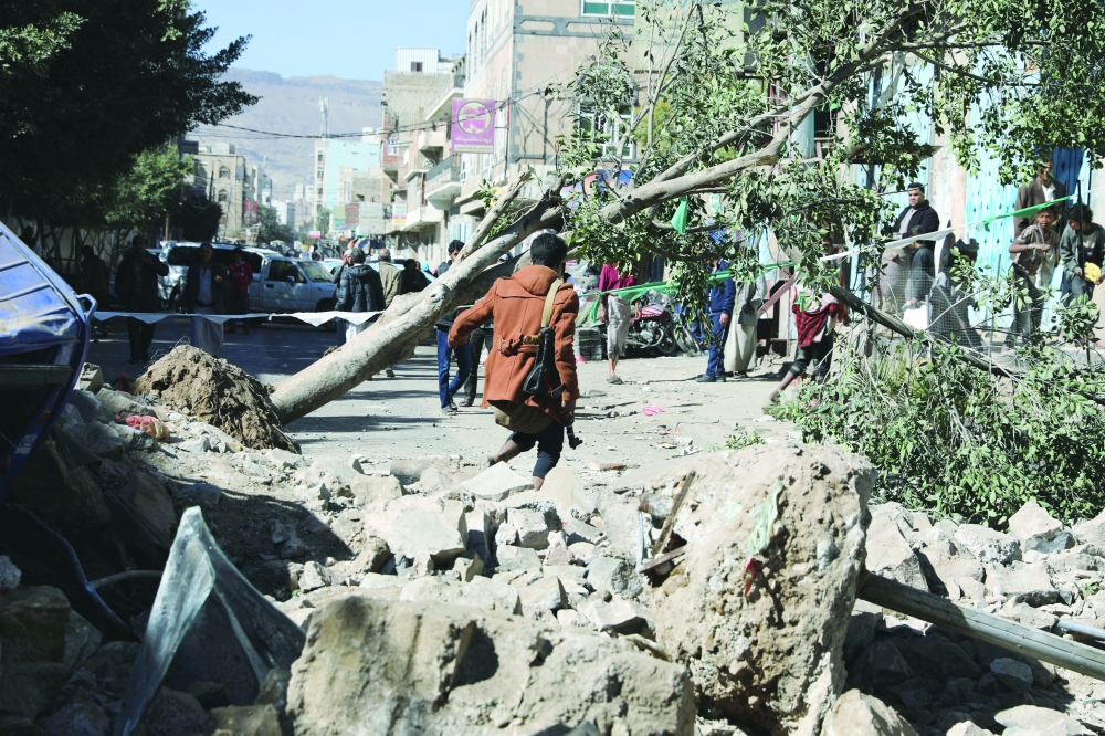 An armed man walks at the site of a Saudi-led air strike in Sanaa on Friday. The coalition fighting in Yemen said on Sunday it struck an Ansar Allah fighter camp in the capital. - Reuters