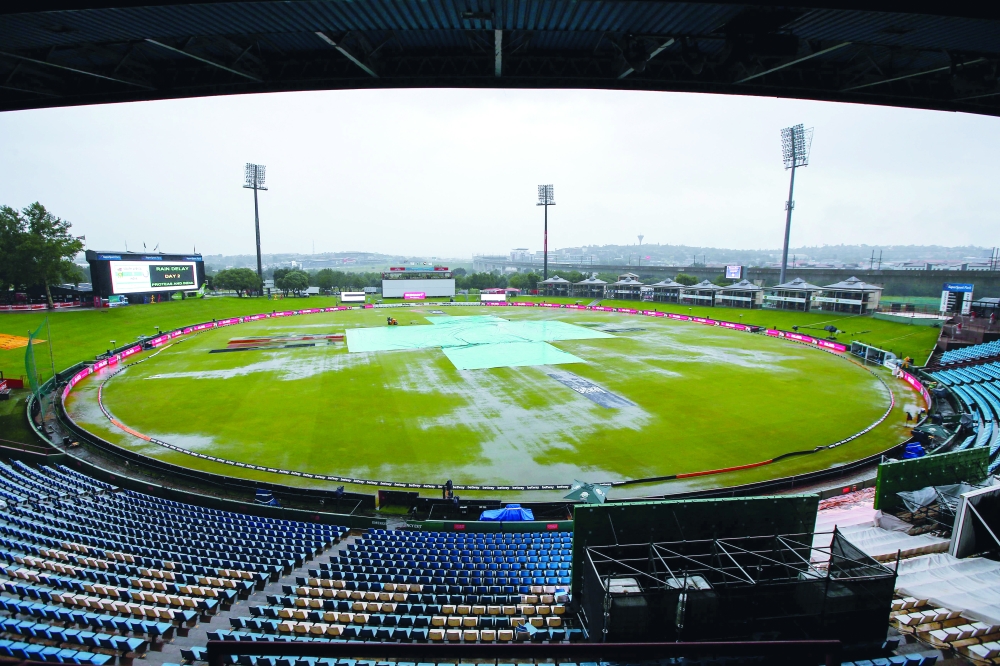 A general view of the rain covers and water on the field as rain has delayed the start of play during the second day of the first Test cricket match between South Africa and India at SuperSport Park in Centurion on December 27, 2021. (Photo by PHILL MAGAKOE / AFP)

