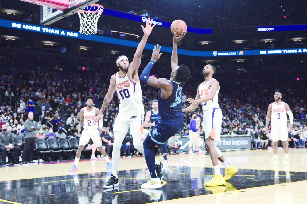 Dec 27, 2021; Phoenix, Arizona, USA; Memphis Grizzlies forward Jaren Jackson Jr. (13) shoots the ball over Phoenix Suns center JaVale McGee (00) during the first half at Footprint Center. Mandatory Credit: Joe Camporeale-USA TODAY Sports
