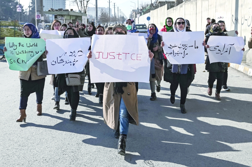 Women hold placards during a protest to demand an end to the extra-judicial killings of former officials of the previous regime, in Kabul on Tuesday. - AFP