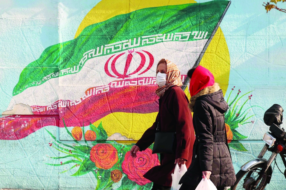 Iranians walk down a street in the capital Tehran on Tuesday. - AFP