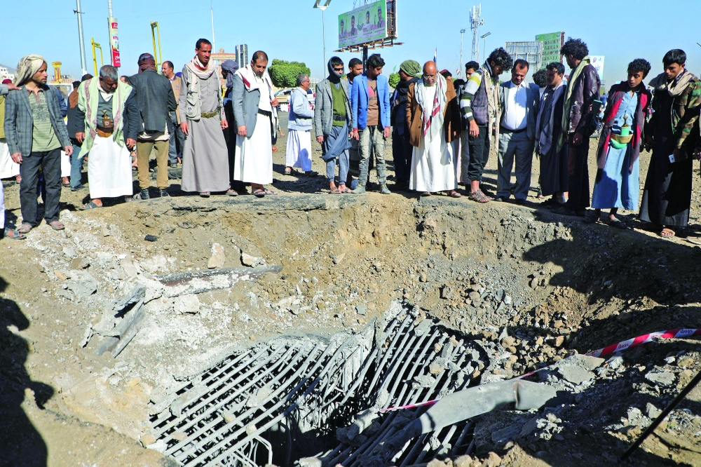 Yemenis inspect a crater following a reported air strike by the coalition targeting a road at Al Sabeen square in the Ansar Allah-held capital Sanaa, on December 23. - AFP file photo