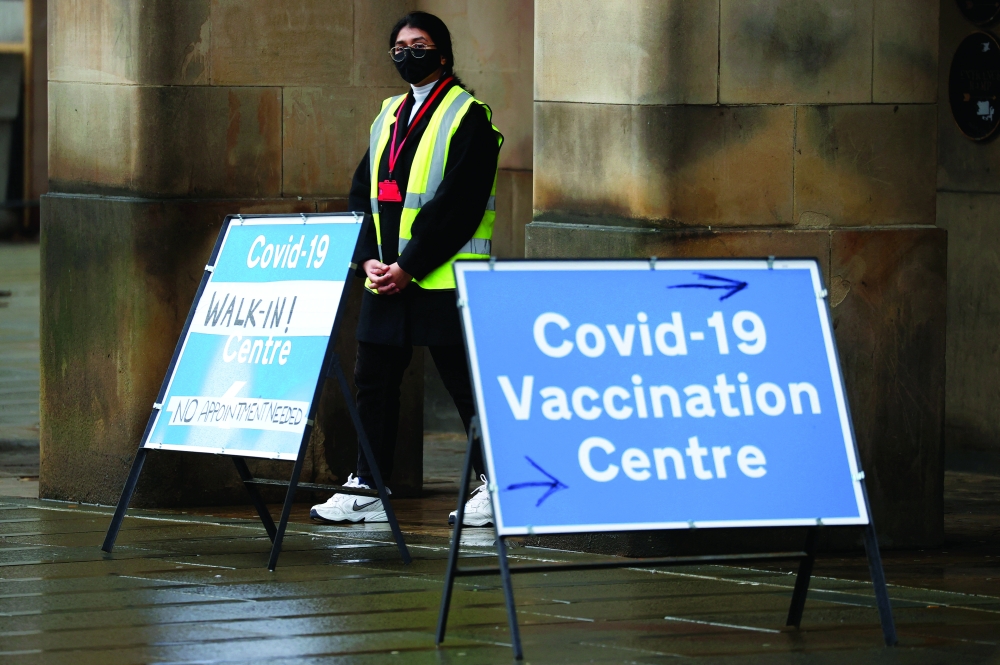 A volunteer stands at the entrance to a vaccination centre, amid the coronavirus disease outbreak in Manchester on Tuesday. Reuters