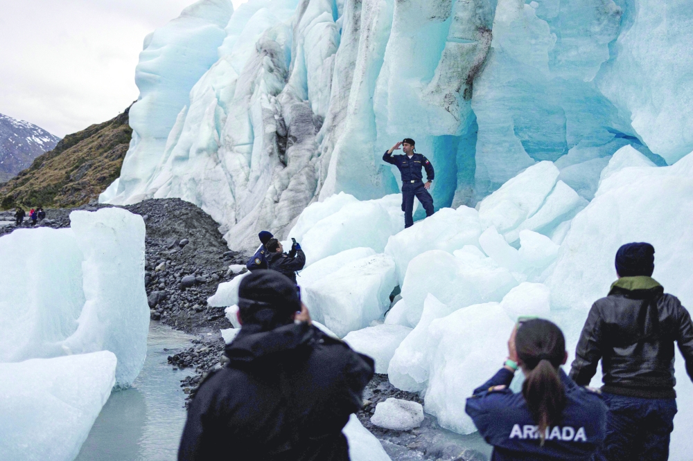 Crew members of the Chilean navy scientific research ship Cabo de Hornos take pictures at the glacier Fouque, in the region of Magallanes, Chile. 