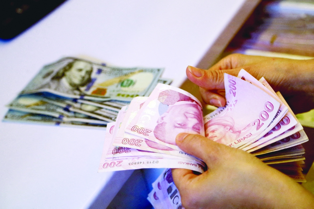 A money changer counts Turkish lira banknotes at a currency exchange office in Ankara. — Reuters file photo 