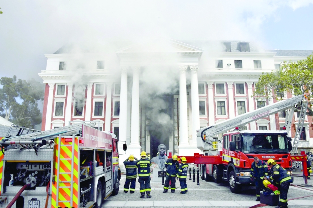 Firefighters battling the fire at the Parliament building in Cape Town. -- Reuters