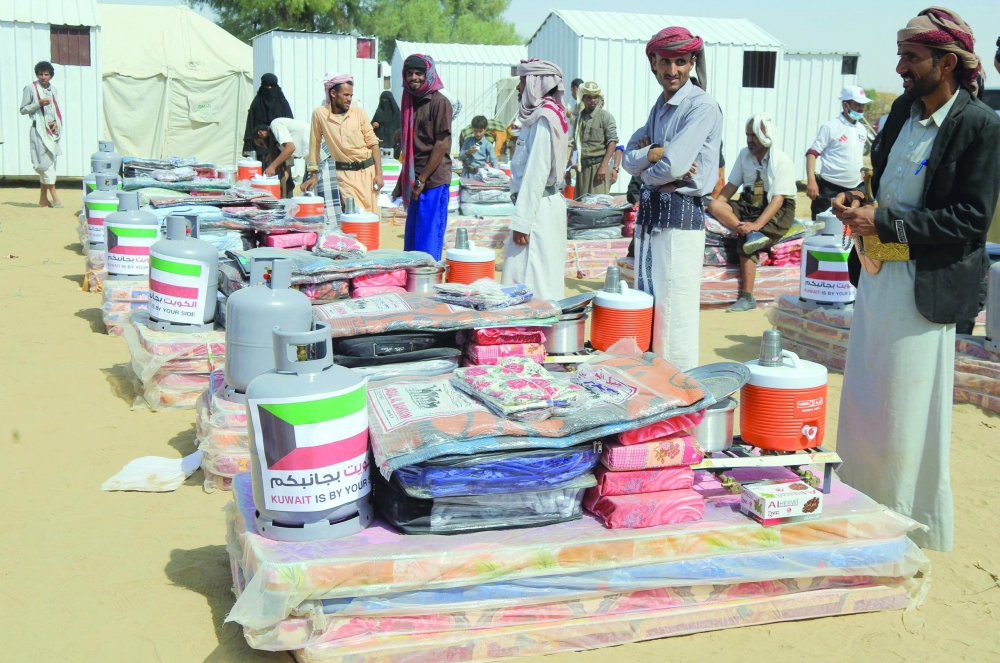 Displaced Yemenis receive aid donated by a Kuwaiti charitable organisation on the outskirts of the northeastern city of Ma'rib, on Saturday. -   AFP