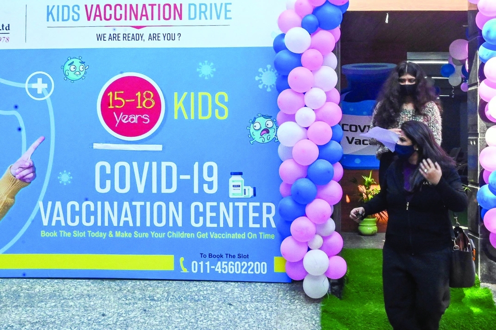 A youth leaves with her parent after receiving a dose of the Covaxin vaccine during a vaccination drive for youths in the 15-18 age group in New Delhi on Tuesday. — AFP