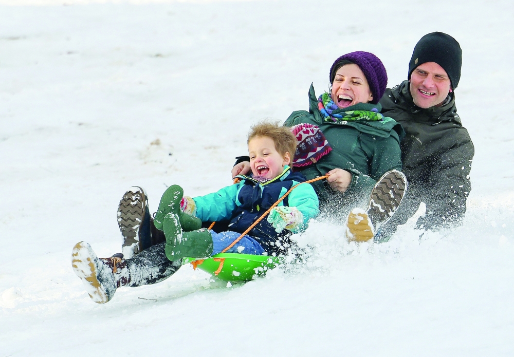 People sled down a hill in Rock Creek Park following a snowstorm in Washington on Tuesday. — Reuters