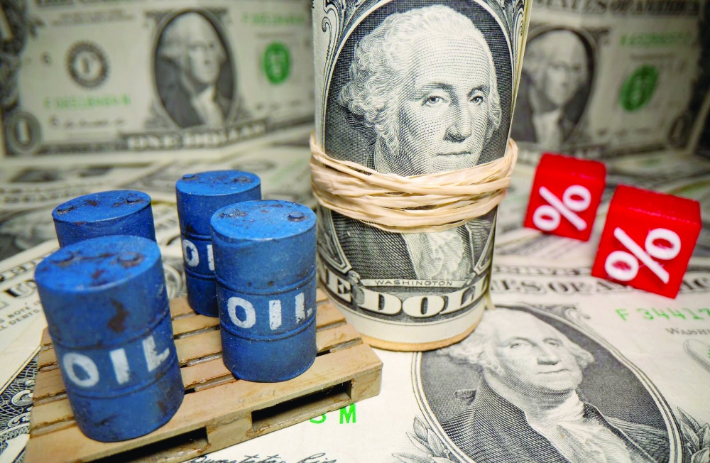 3D printed oil barrels and percentage symbols are seen in front of dollar banknotes in this illustration.  — Reuters