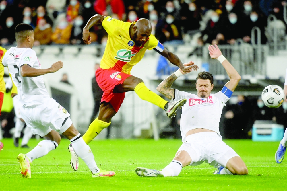 Lens' Ivorian midfielder Seko Fofana (C) kicks the ball past Lille's Swedish defender Gabriel Gudmundsson during the French Cup round-of-32 football match between RC Lens and LOSC Lille at the Bollaert-Delelis Stadium in Lens, northern France on January 4, 2022.  (Photo by FRANCOIS LO PRESTI / AFP)

