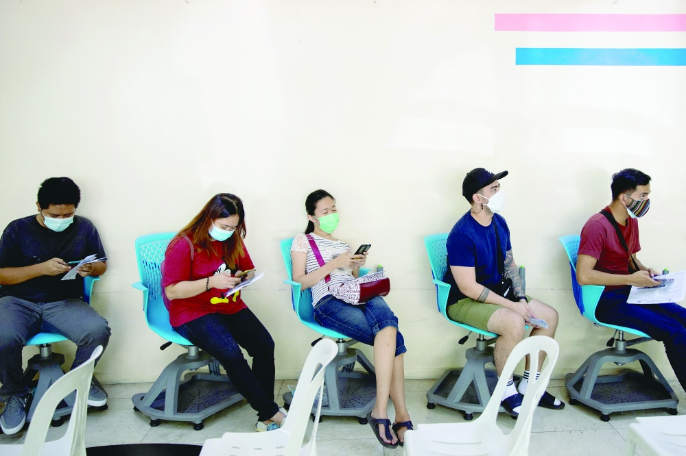 Filipinos queue for a Covid-19 booster dose in Makati City. -- Reuters