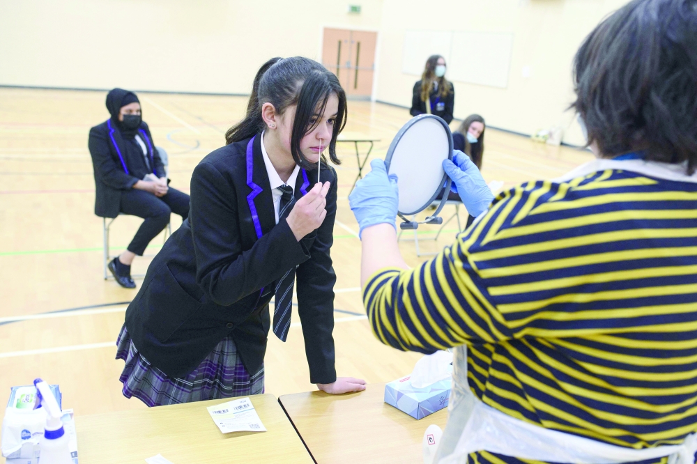 A student at Park Lane Academy takes a Covid-19 lateral flow test in the school Sports Hall, which will be processed by a member of staff during a programme to test every pupil in the school on the first day of term, in Halifax, northwest England on Wednesday. — AFP