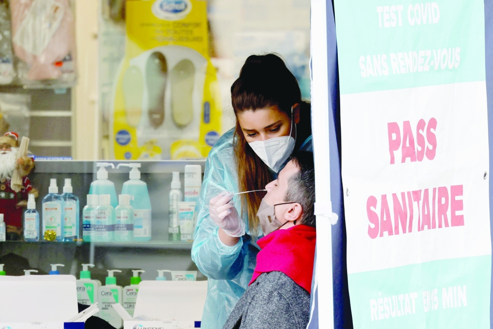 A pharmacy employee collects a sample from a member of the public in a tent set up to offer Covid-19 antigen tests outside a pharmacy in Paris on Thursday, as Covid-19 (novel coronavirus) cases soar in Europe. — AFP 