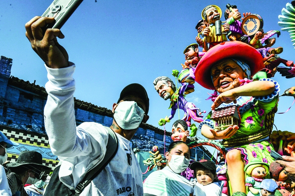 People take selfies during the Blacks and Whites' Carnival - the largest festivity in the south-western region of Colombia - in Pasto, on Thursday. The Carnival, which has its origins in a mix of Andean, Amazonian and Pacific cultural expressions, is celebrated yearly and has been on UNESCO's list of intangible cultural heritage since 2009. - AFP

