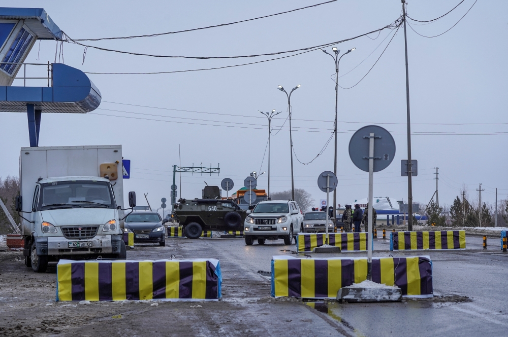 Kazakh law enforcement officers stand guard at a checkpoint, after mass protests triggered by fuel price increase erupted all over the country, in Nur-Sultan, Kazakhstan January 7, 2022. Picture taken January 7, 2022. REUTERS/Turar Kazangapov
