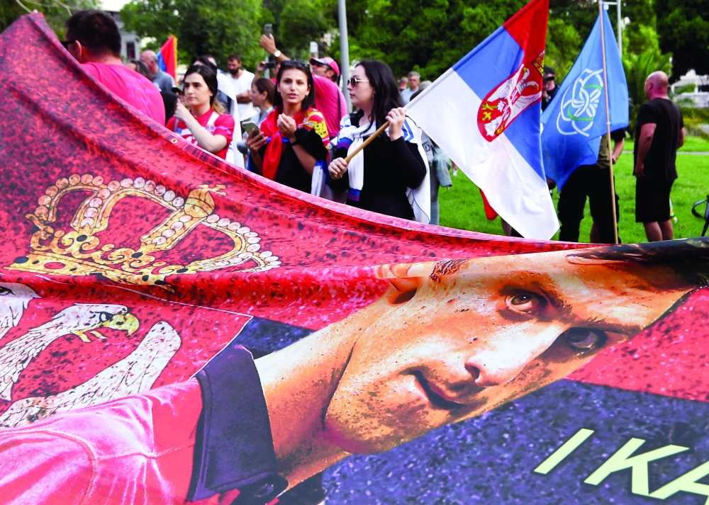 Members of the local Serbian community hold flags and banners outside a government detention centre where Serbia's Novak Djokovic is staying in Melbourne. -- AFP