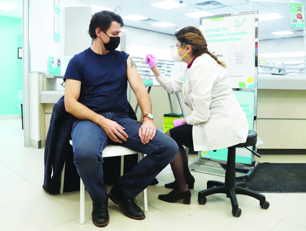 Canada's Prime Minister Justin Trudeau receives a Covid-19 booster dose at a pharmacy in Ottawa. Trudeau called the behavior seen on the plane “a slap in the face” to people who have abided by Covid restrictions on planes and at home. -- Reuters 