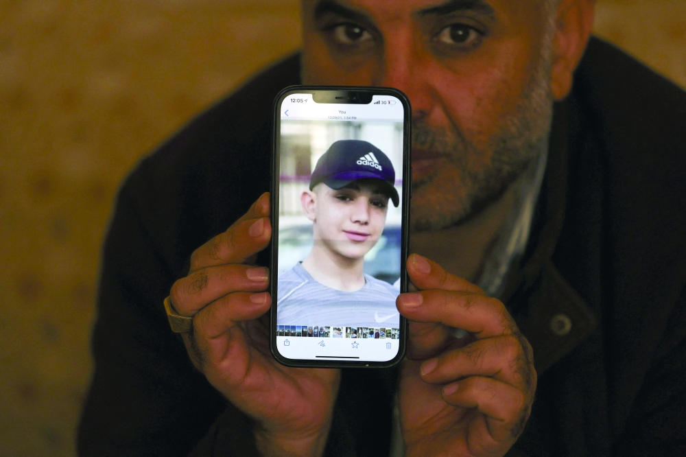 Moammar Nakhleh, the father of Palestinian prisoner Amal, shows a photograph of his son on his telephone, in Jalazun refugee camp, near the occupied West Bank city of Ramallah. - AFP