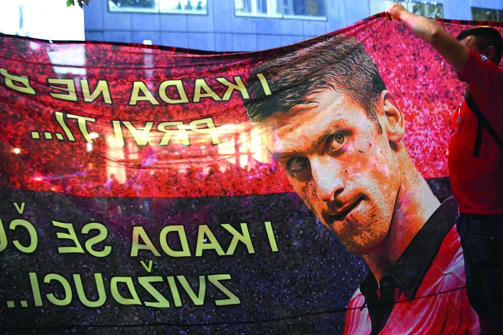 Members of the local Serbian community members hold a banner outside the legal offices where Serbia's tennis champion Novak Djokovic is in with his legal team in Melbourne. -- AFP