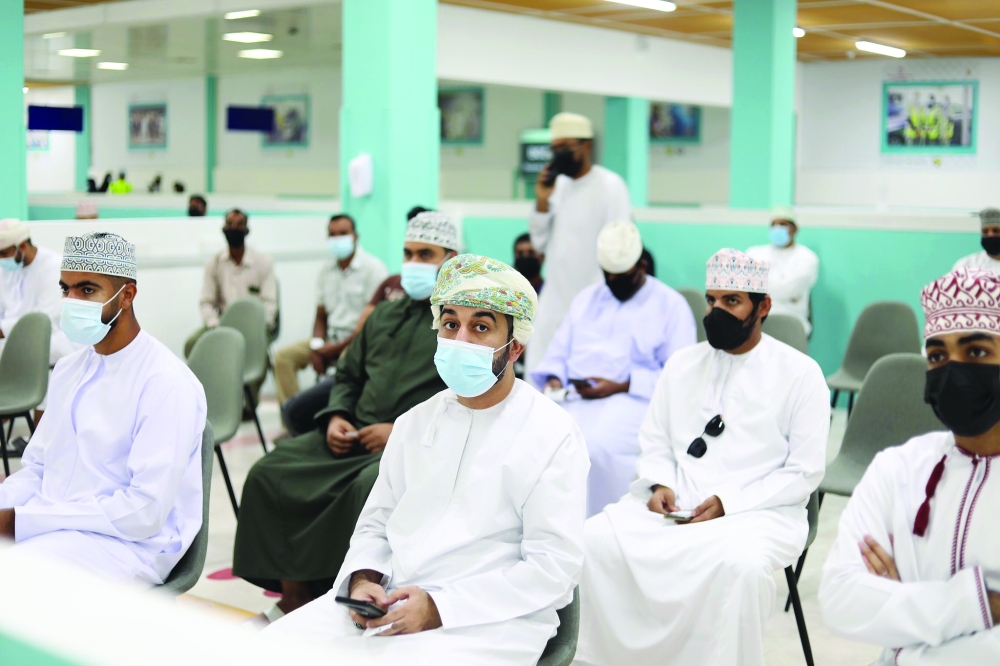 People wait their turn for the third dose of Covid-19 vaccine in Muscat.