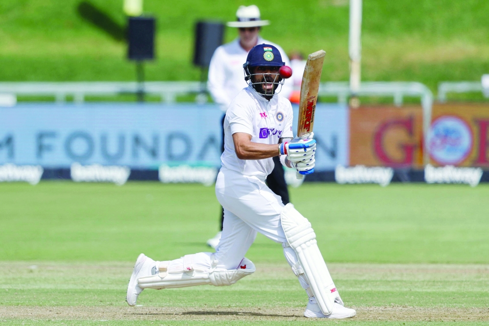 India's Virat Kohli watches the ball after playing a shot during the first day of the third Test cricket match between South Africa and India at Newlands stadium in Cape Town on January 11, 2022. (Photo by Marco Longari / AFP)

