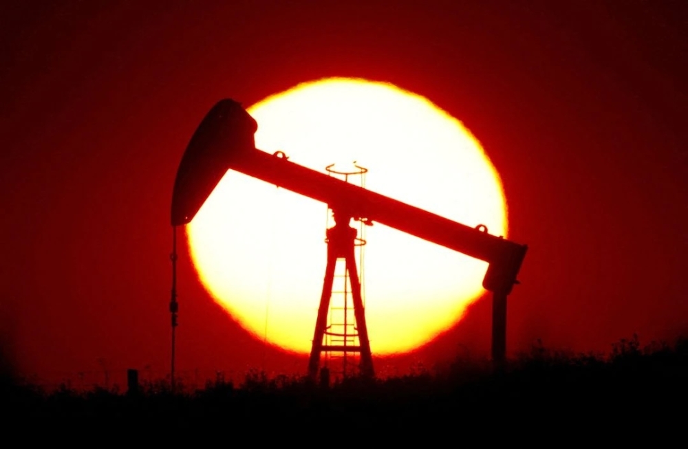 The sun sets behind an oil pump outside Saint-Fiacre, near Paris. — Reuters